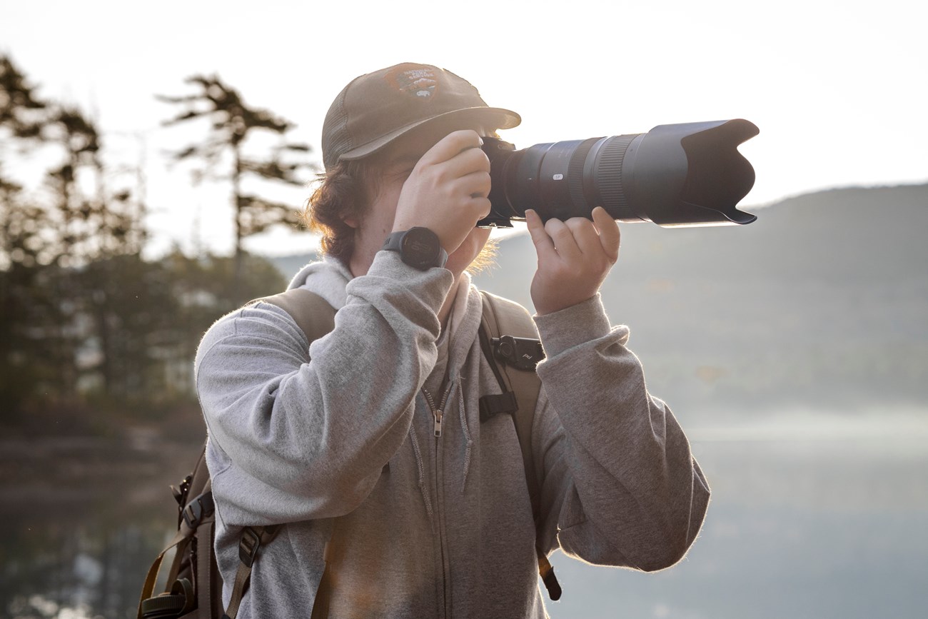 Brady taking a photo with a telephoto lens in the park. Brady taking a photo with a telephoto lens in the park.