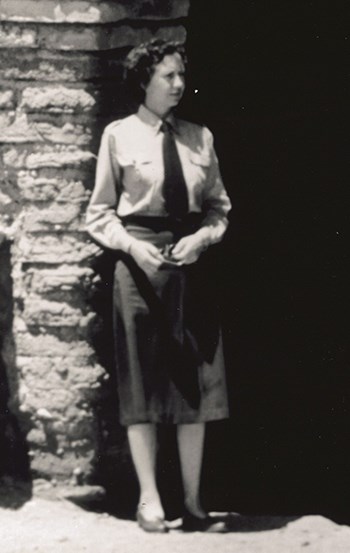 Brewer_Sallie_1947_NPSHPC-George A Grant Photo-HFC#C47-GG-687_croped A woman stands next to a stone pillar. She is wearing an NPS uniform.