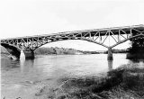 arched bridge with river flowing underneath, black and white