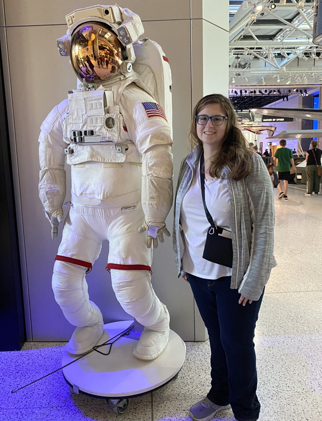 VSFS Intern Alena Buckley standing next to an astronaut display.