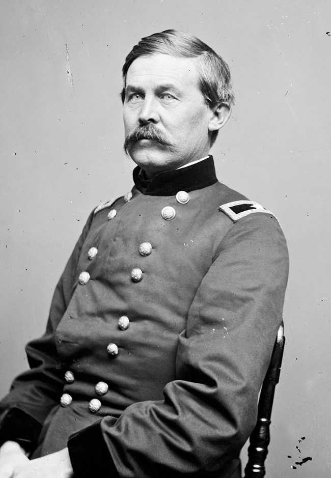 Black and white historical photo of US cavalry commander John Buford, sitting in military uniform