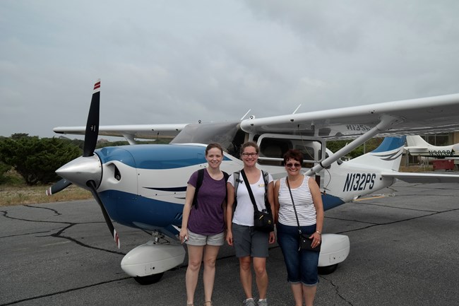 Leah Edwards, Stephanie Nelson, and Gina Belknap, Southeast Region (SER) Facility Management Systems Specialist (Network), prepping for plane ride over Cape Hatteras National Seashore, June 2015 Leah Edwards, Stephanie Nelson, and Gina Belknap, Southeast Region (SER) Facility Management Systems Specialist (Network), prepping for plane ride over Cape Hatteras National Seashore, June 2015
