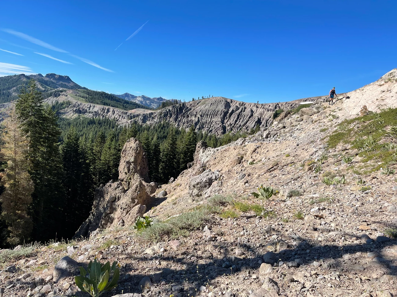 Wagon chute coming up roller pass from east Rocky landing overlooking a steep decline. A hiker is seen in the distance
