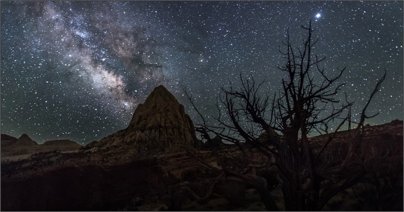 star light, star bright... Mountain silhouetted by a dark sky lit by millions of stars.