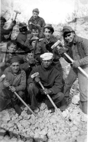 a group of young men stand and kneel holding sledgehammers