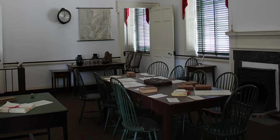Committee room from the 1700s with Windsor chairs surrounding a wooden table in the center of the room. Committee room from the 1700s with Windsor chairs surrounding a wooden table in the center of the room.