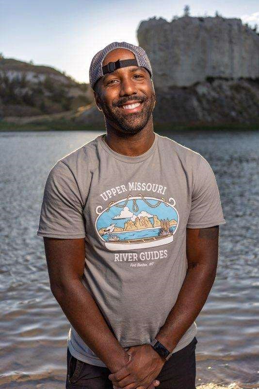 CJ a black man smiling wearing a backwards cap