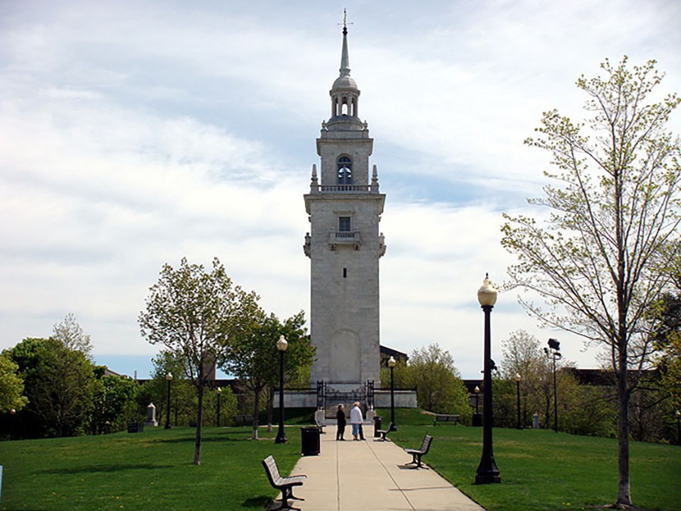 View of Dorchester Heights Monument with sidewalk leading up to it and grass on either side.