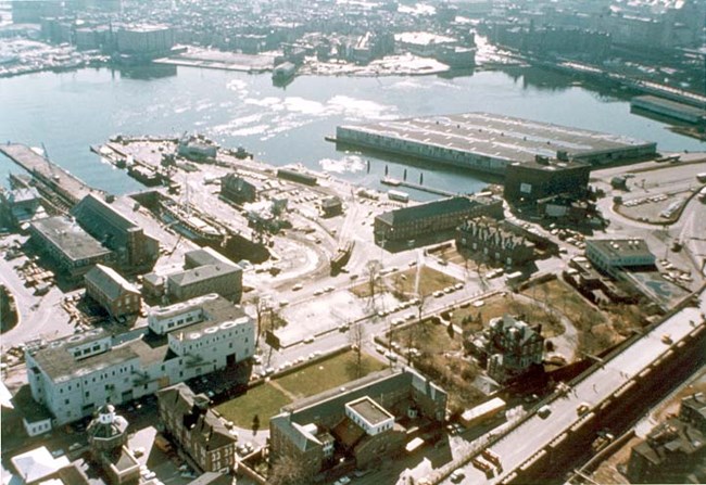 Aerial view of the Charlestown Navy Yard from the 1970s, with Boston harbor in the background.