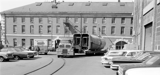 a trailer transports a part of a shift through a parking lot.