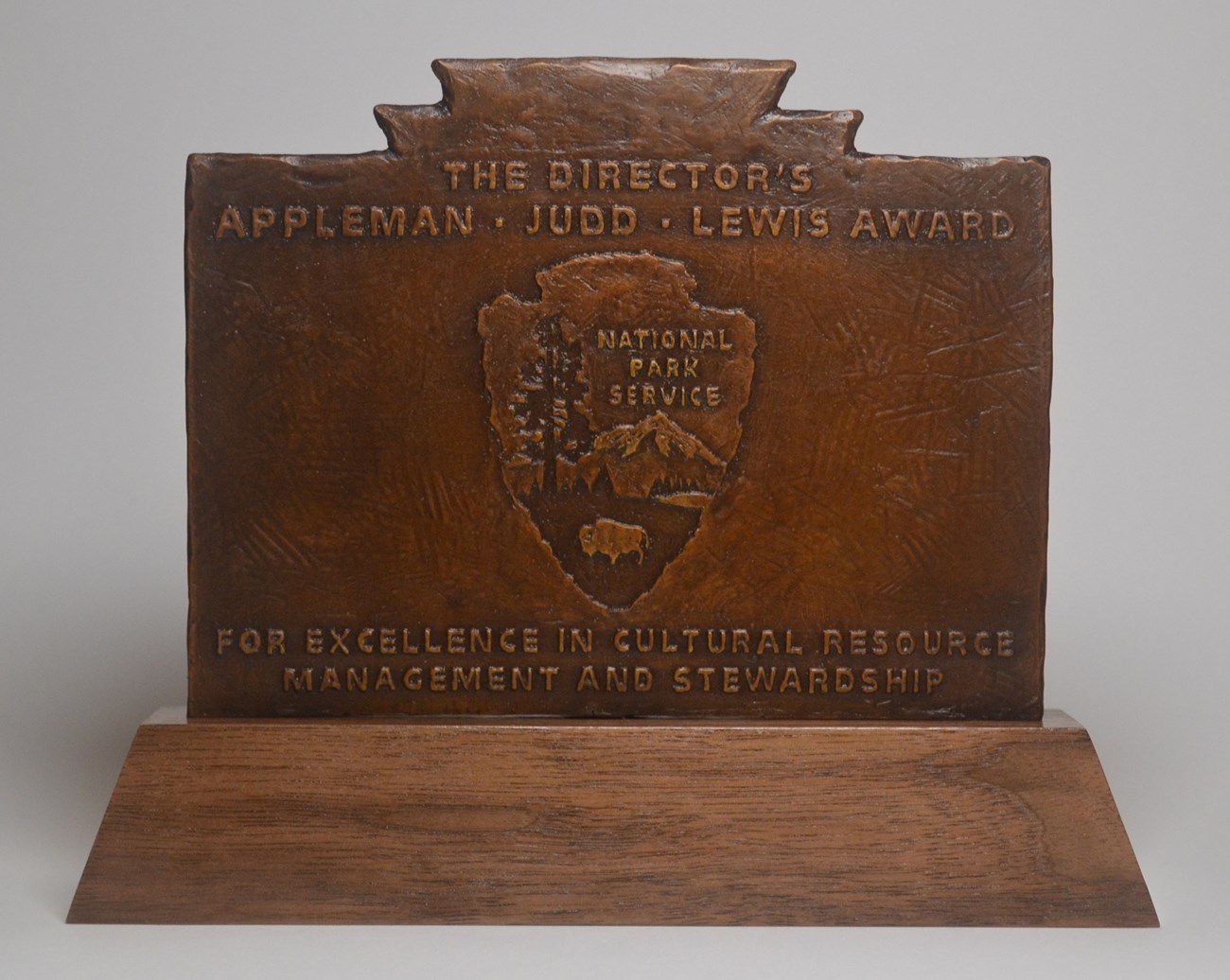 a statuette of a rectangular award with arrowhead logo and the Appleman Judd Lewis Award for excellence in cultural resource management and stewardship