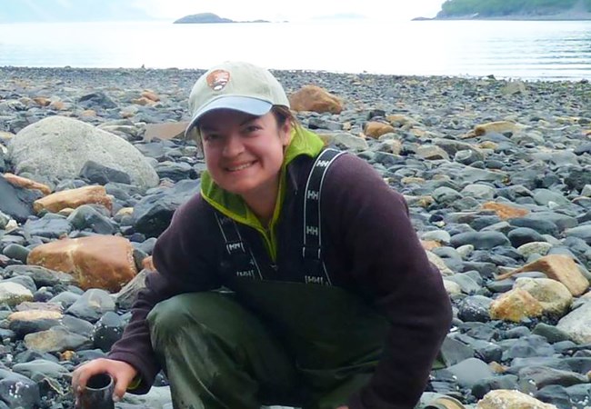 A young woman on a rocky shore.