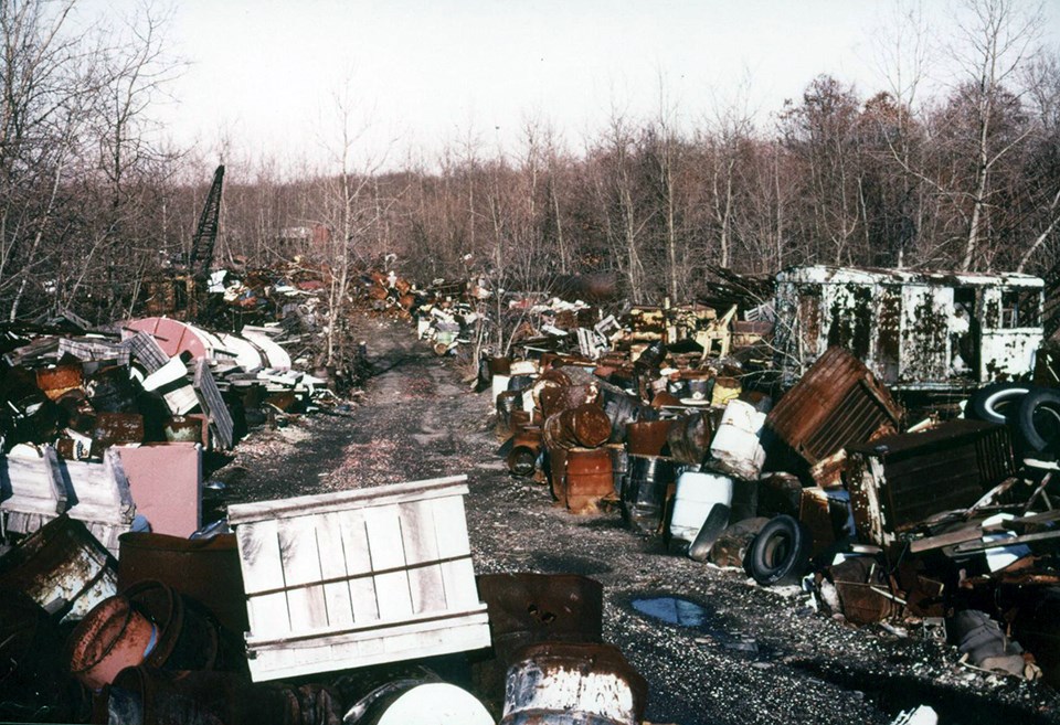 Krejci Dump Metal waste, tires, and other garbage in giant piles in a clearing in a forest.
