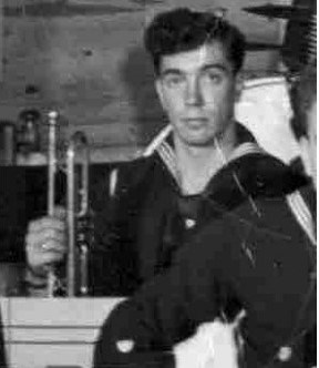 a young man in a coast guard uniform sits holding a trumpet