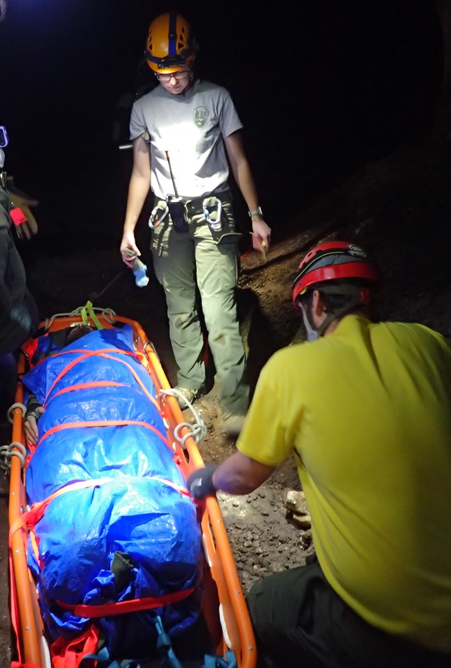 rescue crew with practice victim in a cave