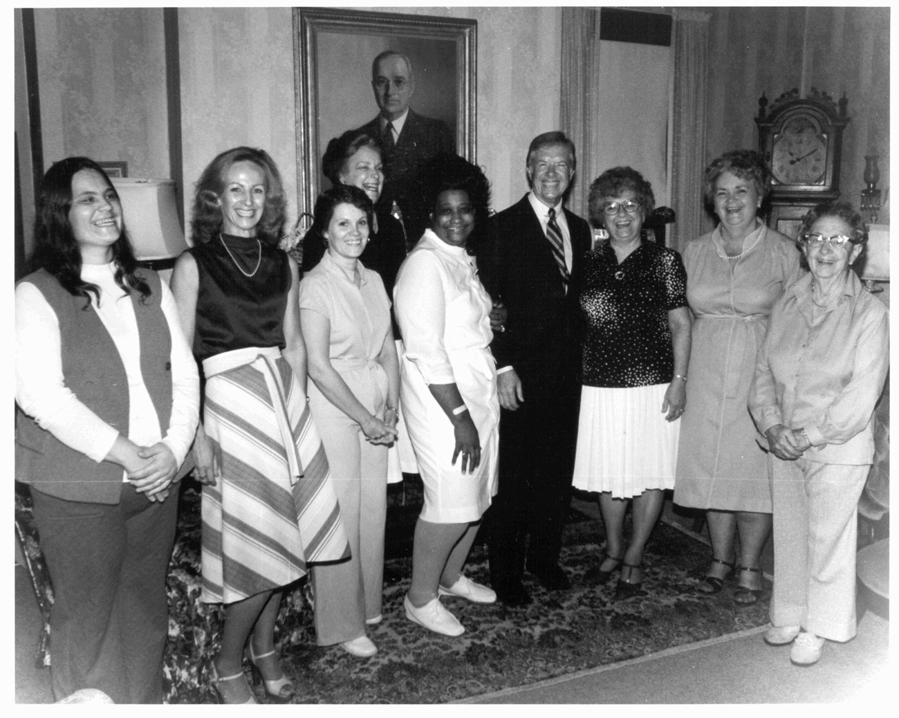 Jimmy Carter, with Mrs. Truman's aides and nurses, in front of a painting of President Harry S Truman by Jay Jacobs. In the Truman Home living room, 1980. President Carter was paying a visit to Mrs. Truman. President Jimmy Carter posing with Mrs. Truman's aides in front of painting of Harry Truman, 1980
