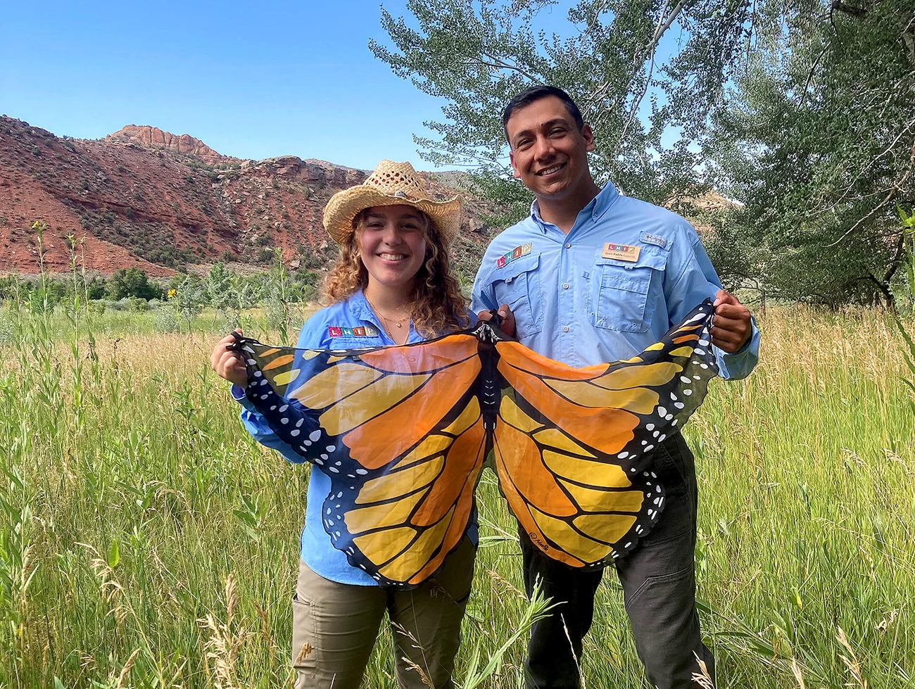 Authors Cavezza and Esparza-Limón holding a monarch butterfly flag Authors Cavezza and Esparza-Limón holding a monarch butterfly flag