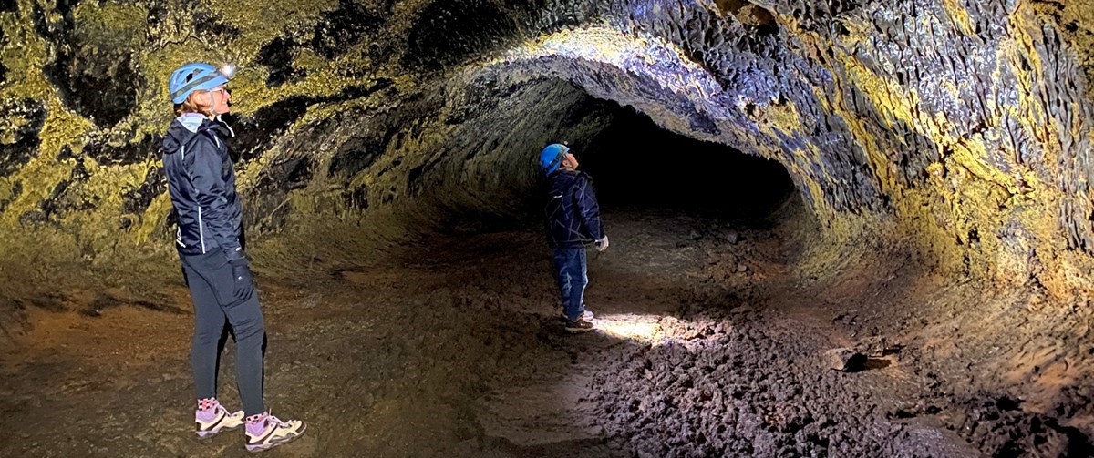 Caving_Main_Image photo of 2 people standing in a lava tube