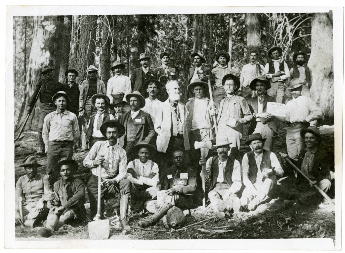 Black and White photo of a large group of men standing in three rows.