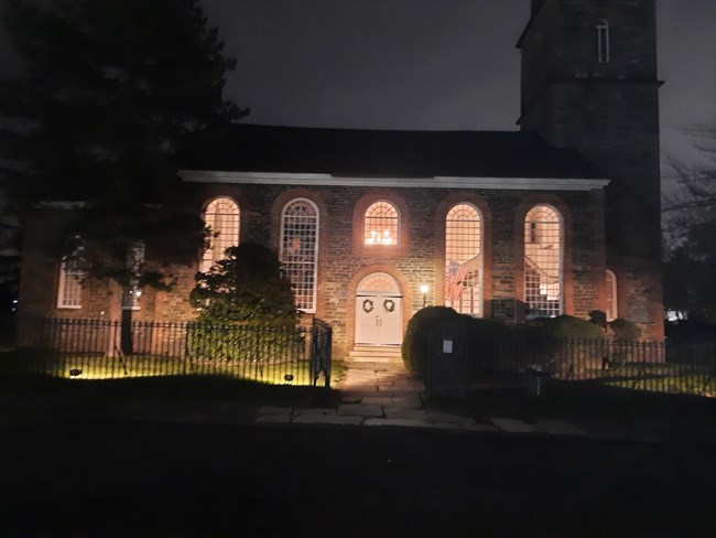 Image of a masonry church, at night, illuminated by flood lights