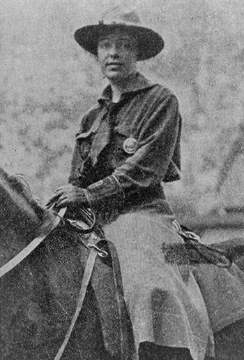 Clare Hodges in her temporary ranger uniform sitting astride a horse in a field.
