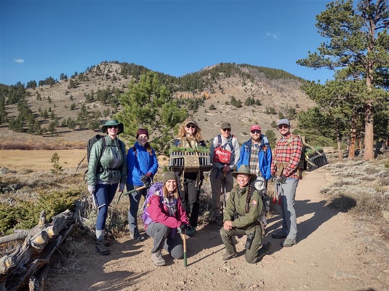 A group of NPS staff and volunteers are pictured standing outside while working on a limber pine planting project A group of NPS staff and volunteers are pictured standing outside while working on a limber pine planting project