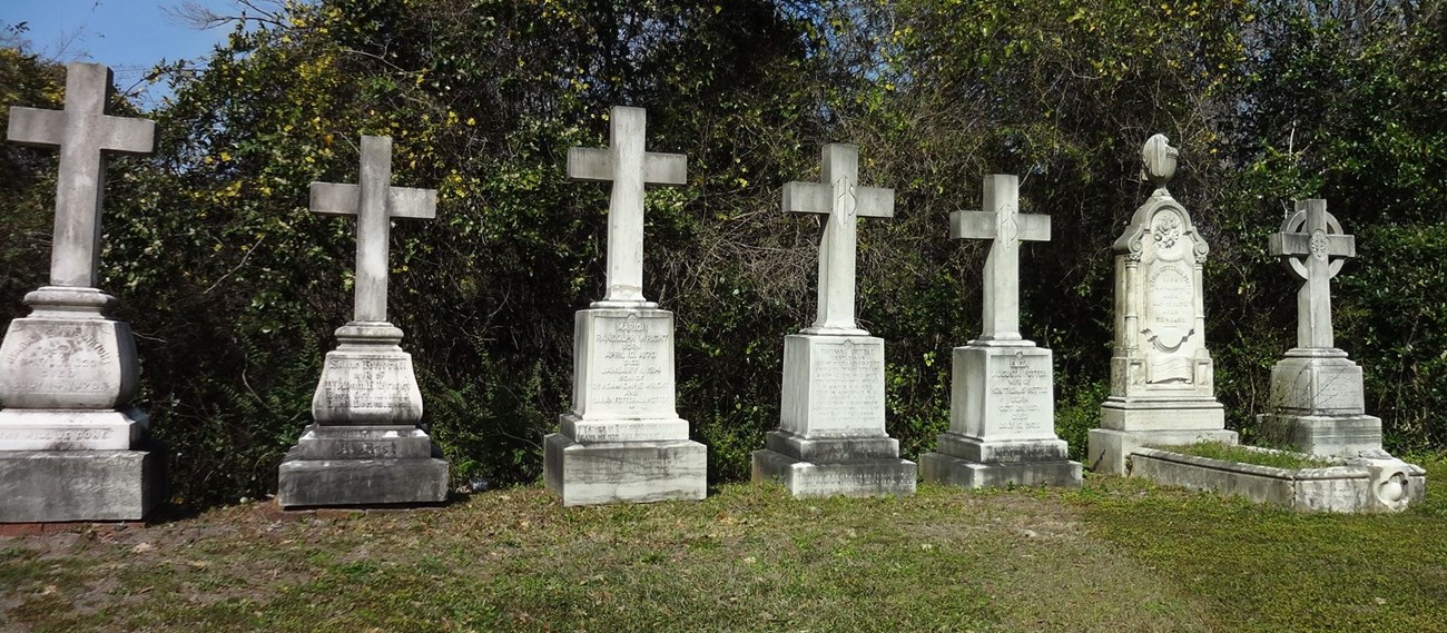 Stone crosses atop pedestal grave markers.