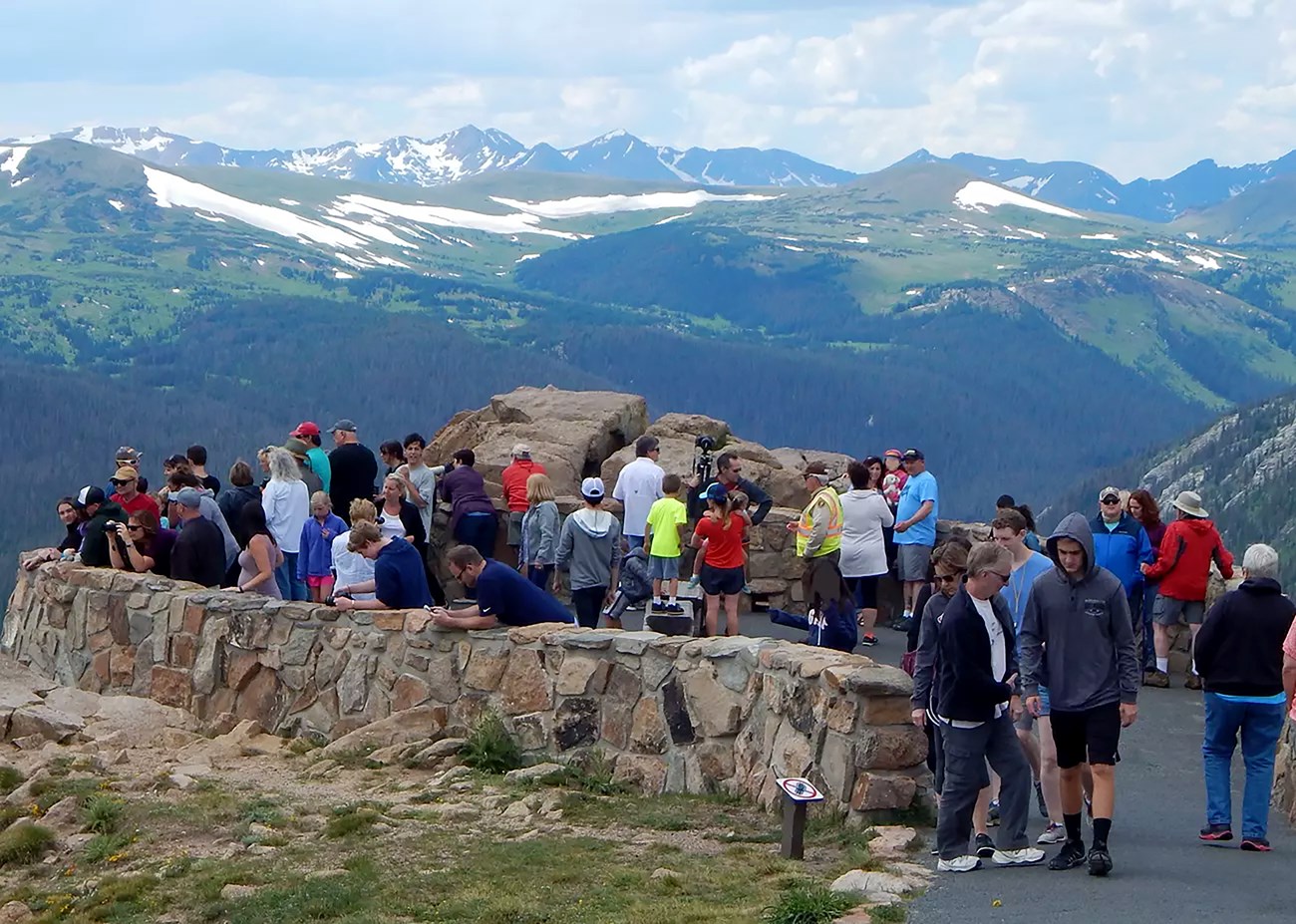A mountain view with an overlook crowded with visitors
