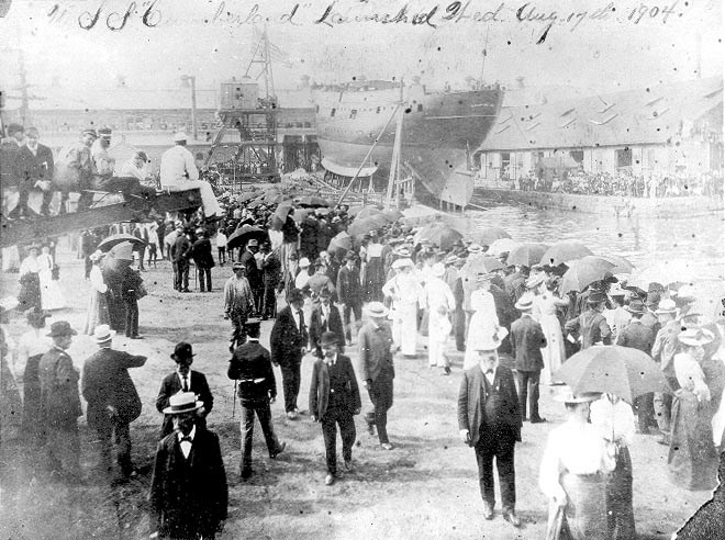 Crowd of people gathrering around a ship for its launching.