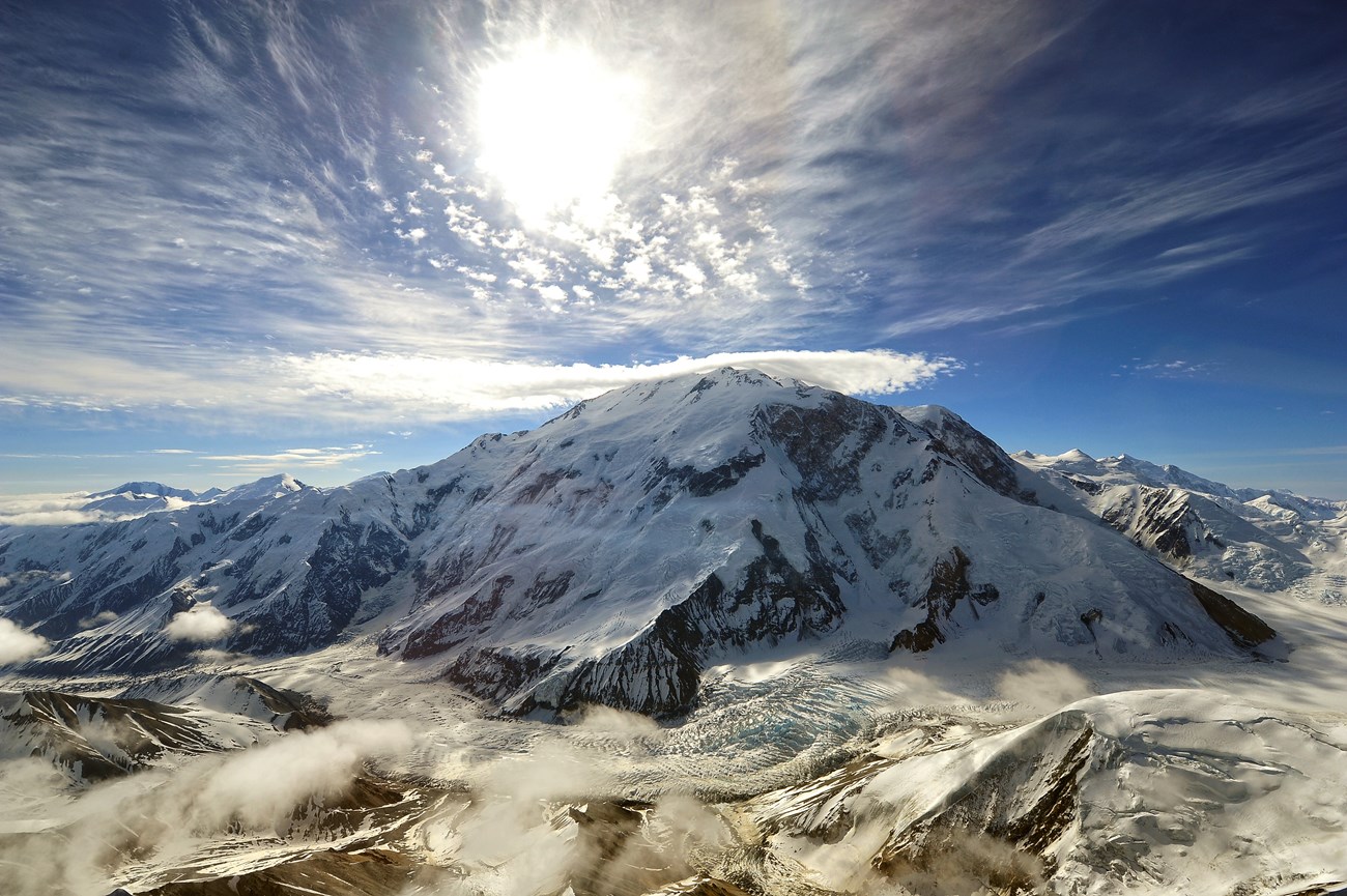 Part of a snow-covered mountain face and peak