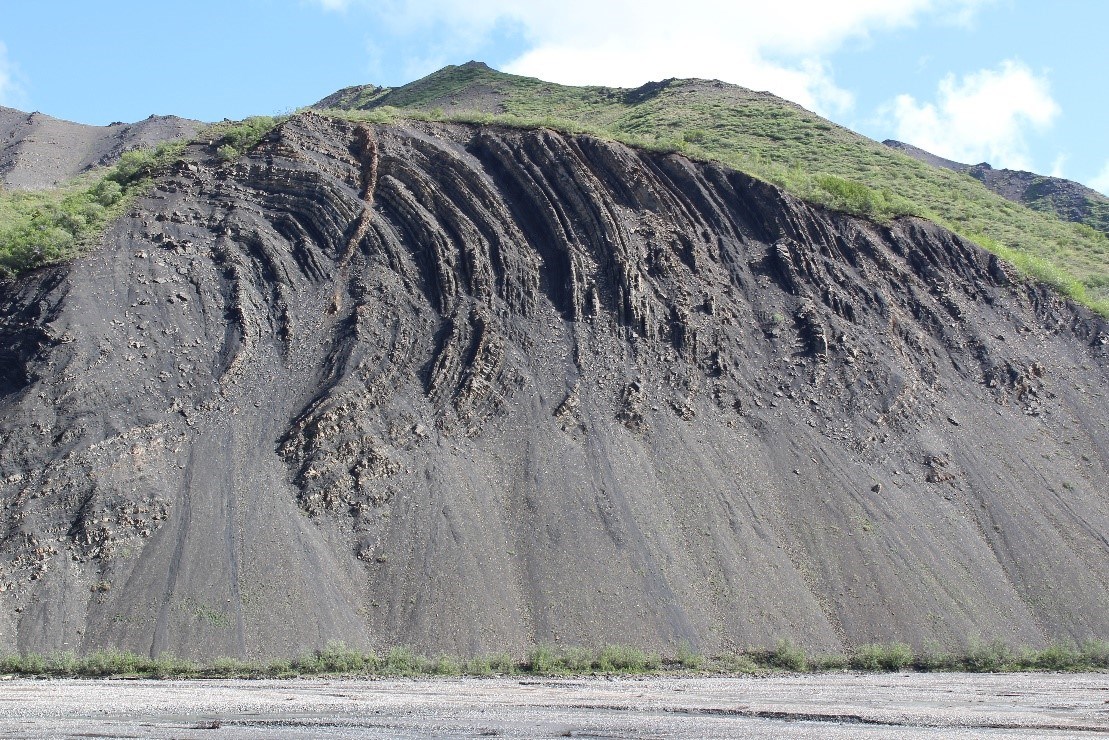 barren hillslope with exposed rock layers near the top