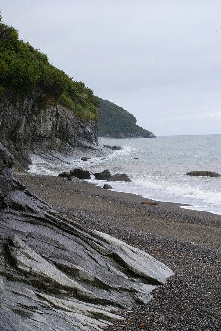 A rocky shoreline with cliffs at the edge of the water