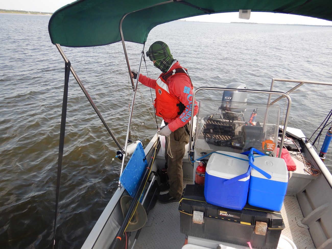 Man in a boat pulling up a tube of water