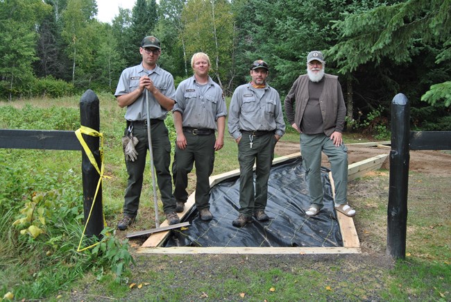 Left to right, Mason Meyer, Jamie, Callais, Jason Christenson, and David Driapsa on the accessible trail under construction at the comfort station at Ellsworth Rock Garden, Voyagers National Park.