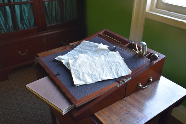 A wooden travel desk sitting on a table.