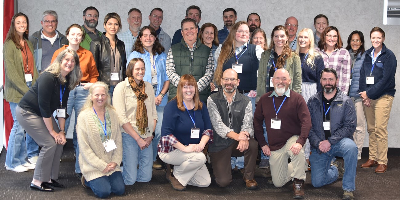 FY2025 SECN SC Meeting Group of people wearing name tags around their necks posing for a photo.