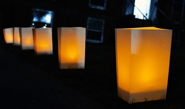 A row of luminaria lining a sidewalk.