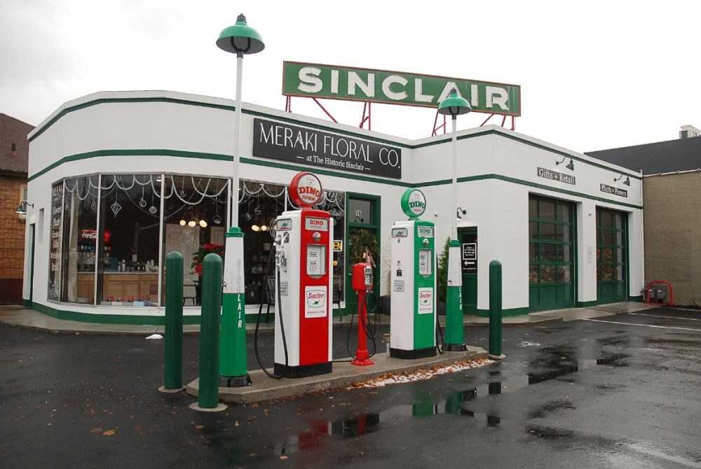 Exterior Sinclair Service Station repurposed as a flower shop. Original streetlamp and pump stations remain.