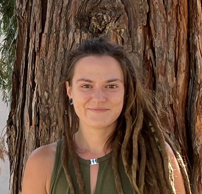 Smiling woman with blond dreadlocks.