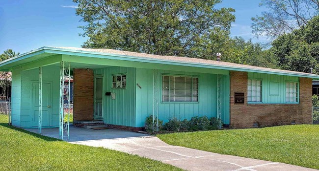 One-story green home with a prominent carport