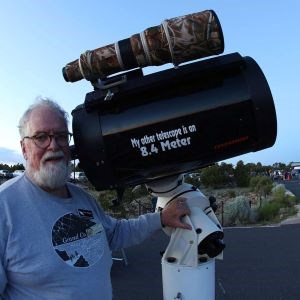 Dean Ketelsen A man in a “Grand Canyon Star Party” shirt stands beside a large telescope.