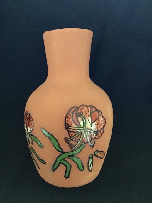 A brown clay pot with a flower painted on the side.