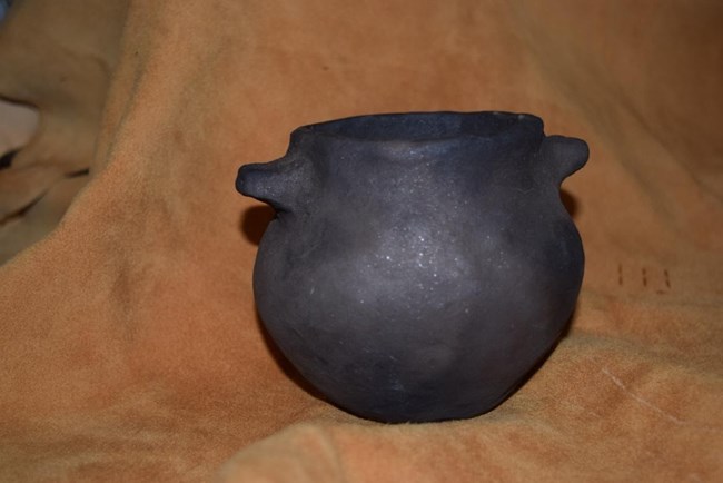 A simple, black pot with two handles.
