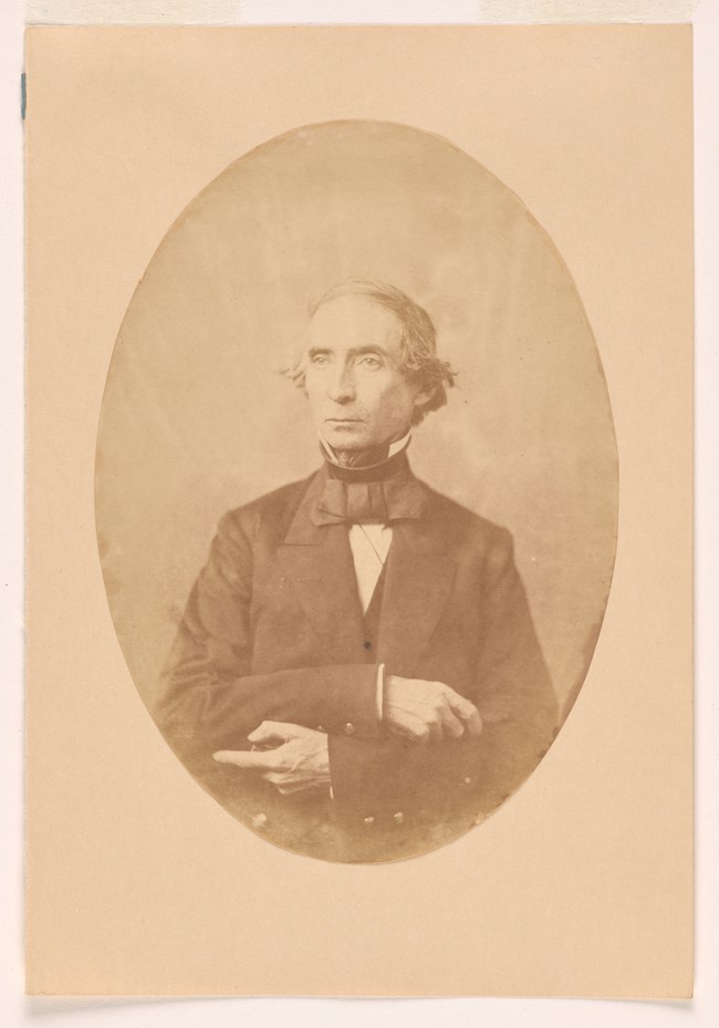 Dennis Hart Mahan - Smithsonian National Portrait Gallery Sepia colored salt print photo of a man wearing a suit and bow tie.