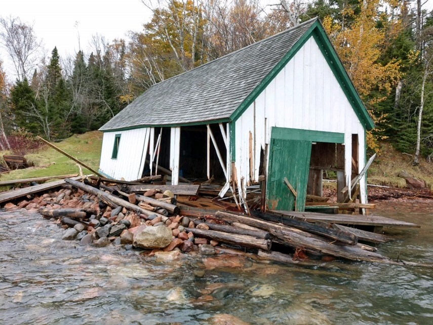 Devil's Island Boathouse is in pieces after a storm that is being swept away by water. Devil's Island Boathouse is in pieces after a storm that is being swept away by water.