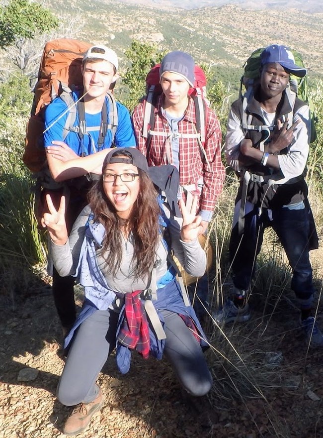 EMC citizen scientists 3 a group of 4 young adults wearing backpacks on a trail