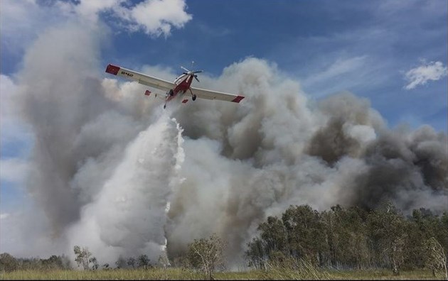 Single Engine Air Tanker dropping water on wildfire.