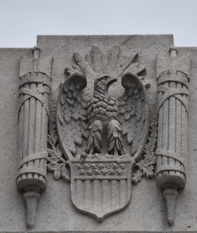 Photo of an Eagle sculpture on a building in gray stone
