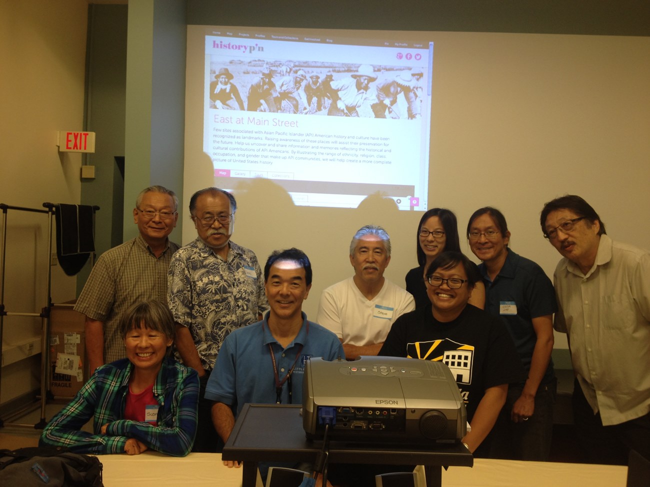 Los Angeles, CA Group photo of 9 Asian men and women siting in front of a screen.