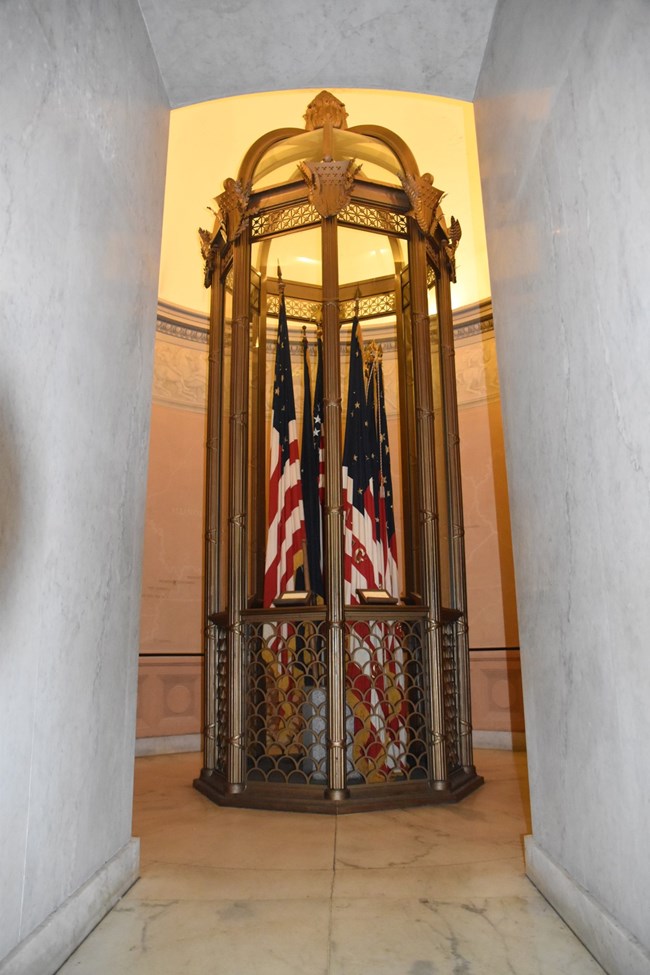 Bronze case with glass windows containing various flags